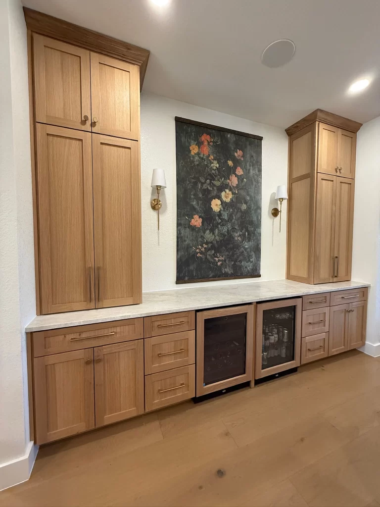 A modern living space featuring wooden cabinets with upper and lower sections, a marble countertop, and a decorative floral painting on the wall.