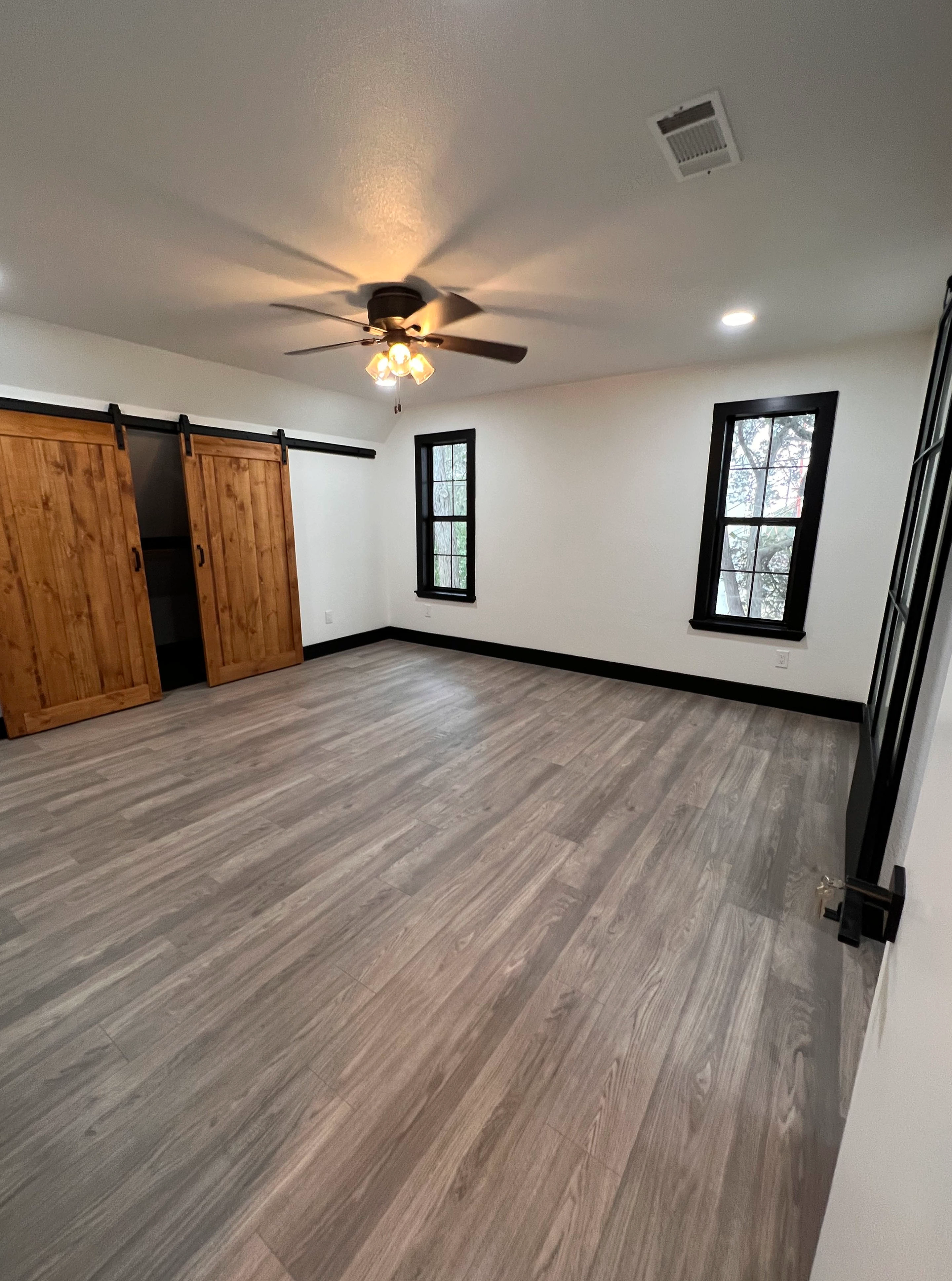 Home remodel in New Braunfels with kitchen remodel and bathroom remodel completed including custom barn doors in master bedroom by Kirk Homes Services.
